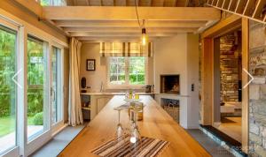马尔梅迪Côté Mont的厨房设有一张大木桌和大窗户。