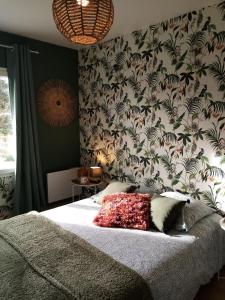 卡布尔O Douceurs Sucrées Cabourg的一间卧室配有一张带花卉壁纸的床