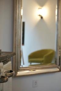 文斯托夫Landhotel Strandallee的镜子和绿椅