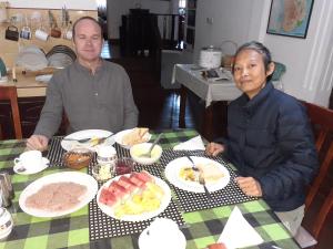康提Kandy Mountain Cottage的两个坐在餐桌上吃盘子的人