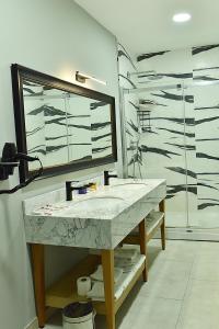 伊斯坦布尔Kerthill Hotel的一间带水槽、镜子和淋浴的浴室
