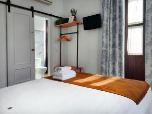 科尔多瓦La Piquera Hostal的卧室配有白色的床和窗户。