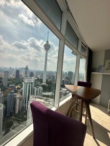 吉隆坡near klcc vortex suites by PLUS POIN的享有西雅图天际线景致的客房内的桌椅