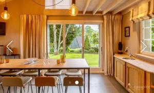 马尔梅迪Côté Mont的一个带桌椅和大窗户的厨房