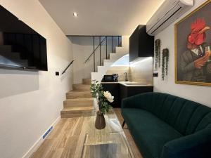 科尔多瓦La Mini Casa的客厅设有绿色沙发和楼梯。