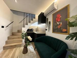 科尔多瓦La Mini Casa的客厅配有绿色沙发和墙上的绘画