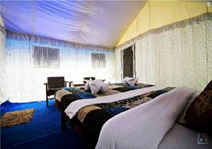 洪达尔Desert Oasis Camp的酒店客房设有两张床和一张桌子。