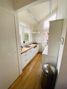 劳雷尔苏格Vakantiehuis Robbenoort 18的厨房配有白色橱柜、水槽和垃圾桶