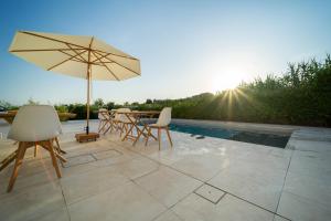 圣尼科拉阿尔切拉Dimora Manfredo Eco B&B Luxury的庭院配有桌椅和遮阳伞。