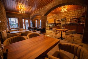 卡尔斯AHISKA PALAS OTEL的配有木桌和椅子的餐厅