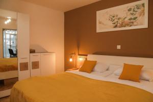 摩拉瓦托普利采Miadora apartments - Apartma Bela štorklja的一间卧室配有带橙色和白色枕头的床