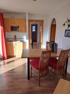 蒂罗尔州圣约翰阿尔皮纳小木屋公寓式酒店的厨房配有木制餐桌和椅子