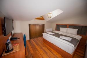 卡尔斯AHISKA PALAS OTEL的一间卧室配有一张大床和一台平面电视