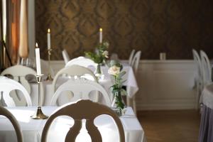 菲利普斯塔德尼格马赫斯庄园酒店的用餐室配有白色的桌子和白色的椅子