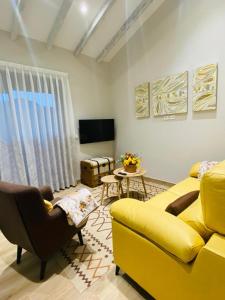 纳维亚El Pueblín del Pinar的客厅配有黄色沙发和电视