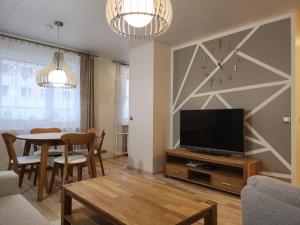 哈普萨卢Kuuse 4 Apartment的一间带电视和桌子的客厅
