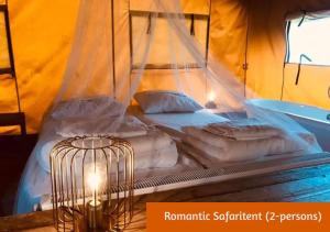 霍尔滕Safaritents & Glamping by Outdoors的帐篷内的一张床位,带笼子