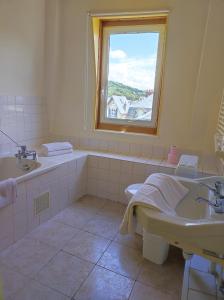 埃特勒塔蓝色魔石酒店的带浴缸、水槽和窗户的浴室