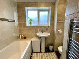布里斯托Double Room in Cosy Quiet Home - House Shared with One Professional的浴室设有水槽和水槽旁的浴缸