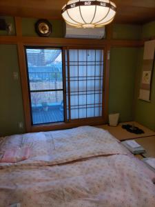 大阪OTERA HOUSE 瑞　TAMA的一间卧室设有一张大床和一个窗户。
