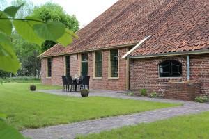 NieuwoldaHoogheem Erfgoed & Logies的院子里的砖屋,配有桌椅