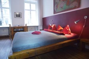 柏林Pension Mädchenkammer的一间卧室配有一张带红色枕头的床