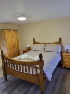 BagenalstownSmall Town House, Barrow Lane, Bagenalstown, Carlow的一间卧室配有一张带枕头的大型木制床。