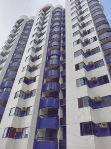 累西腓BOA VIAGEM 2 quartos 100 m da praia até 5 pessoas的一栋高高的公寓楼,设有蓝色的阳台