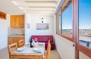 莱乌卡Istoral Apartment Leuca的一间设有桌子的海景用餐室