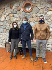 阿尔布斯La Quercia的三人身穿面具站在石墙旁边