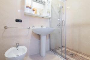 莱乌卡Istoral Apartment Leuca的一间带水槽和玻璃淋浴的浴室