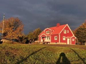 SollebrunnÄppelgården的站在红房子前面的人的影子