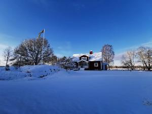 SollebrunnÄppelgården的雪中的房子,上面有旗帜