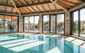巴特拜尔索因索雅湖公园酒店的一个带玻璃窗的室内游泳池和一个大型游泳池
