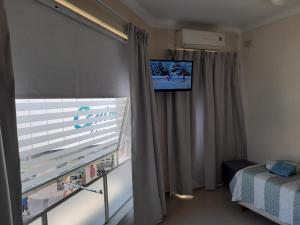 巴拉那Departamento Peatonal的客房设有窗户和墙上的电视。