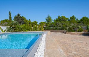丽都玛里尼Villa Crigiada Luxury Pool的一座房子旁的游泳池,设有石头走道