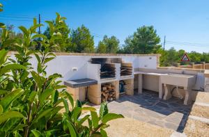 丽都玛里尼Villa Crigiada Luxury Pool的露台上的户外厨房配有烧烤架