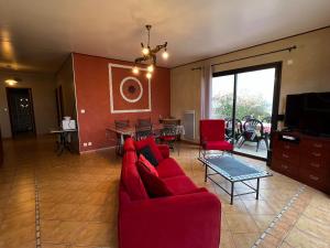 PomportLes Vignes的客厅配有红色的沙发和桌子