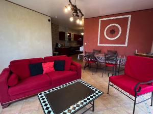 PomportLes Vignes的客厅配有红色的沙发、椅子和桌子