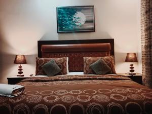 卡拉奇Seaview Lodge Guest House的一间卧室配有一张带两盏灯的棕色床。