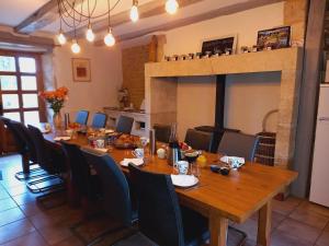 FossemagneAu pays de Jacquou : Chambre d’hôtes et table d’hôtes的用餐室配有长木桌子和椅子