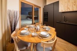 道尼库宾Bird's eye view, Hillside的厨房配有带盘子和玻璃杯的木桌