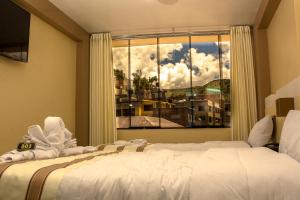普诺Kaaro Hotel Puno的一间卧室设有一张床和一个大窗户