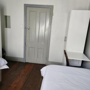 彼得马里茨堡Msunduzi River View backpackers的卧室配有床和白色门