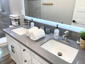 萨克拉门托Luxurious Brownstone Retreat - Walk to DT/Golden1的浴室柜台设有两个盥洗盆和镜子