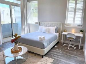 萨克拉门托Luxurious Brownstone Retreat - Walk to DT/Golden1的一间卧室配有一张带书桌和一张书桌的床。