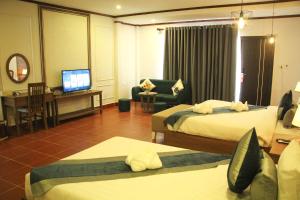 万荣Confetti Garden Resort的酒店客房设有两张床和电视。
