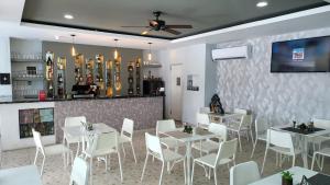 蓬塔卡纳珊瑚广场酒店的用餐室配有白色的桌子和白色的椅子