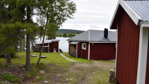 SkauloLakeside cottage in Lapland with great view的水体旁边的两座建筑物