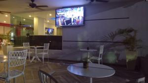 蓬塔卡纳珊瑚广场酒店的一间带桌椅的餐厅以及墙上的电视